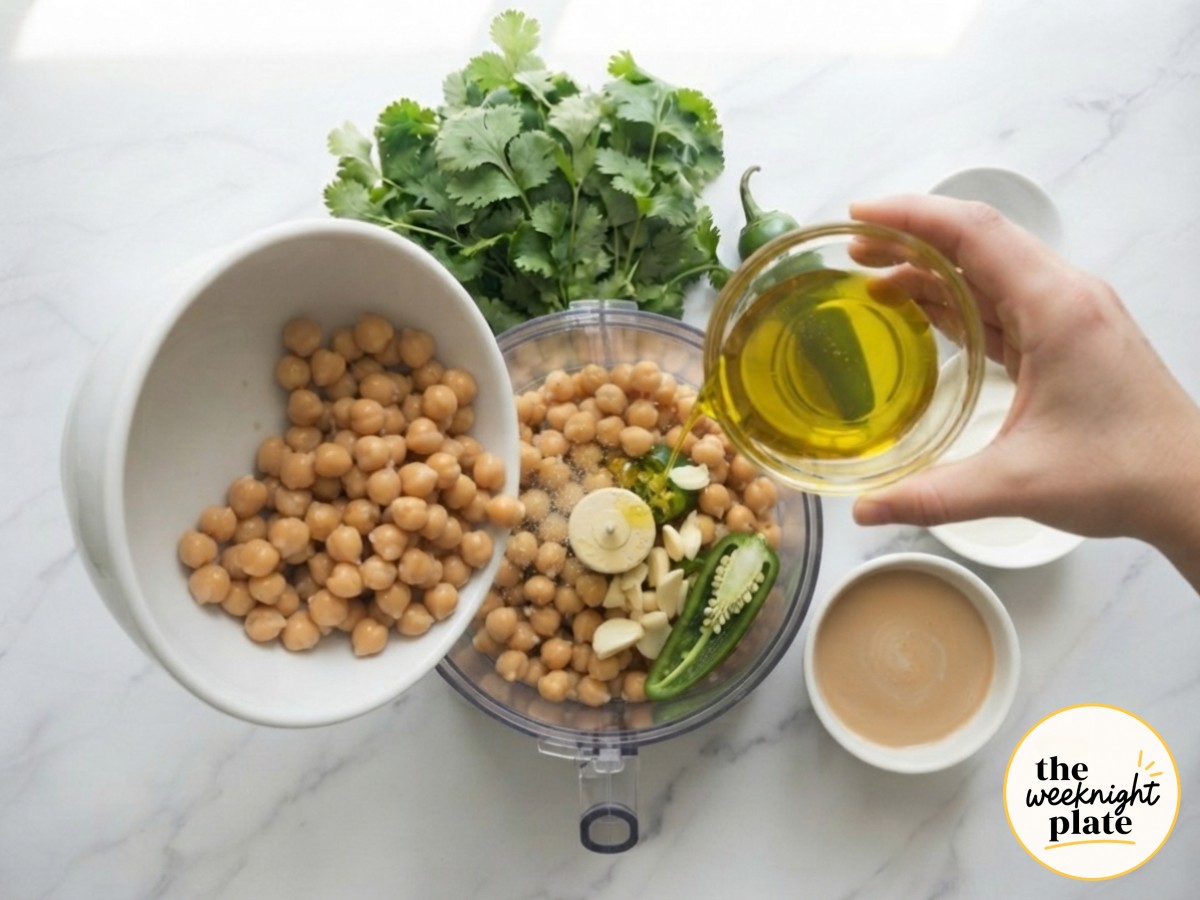 Chickpeas, garlic, and olive oil combining in a food processor for hummus