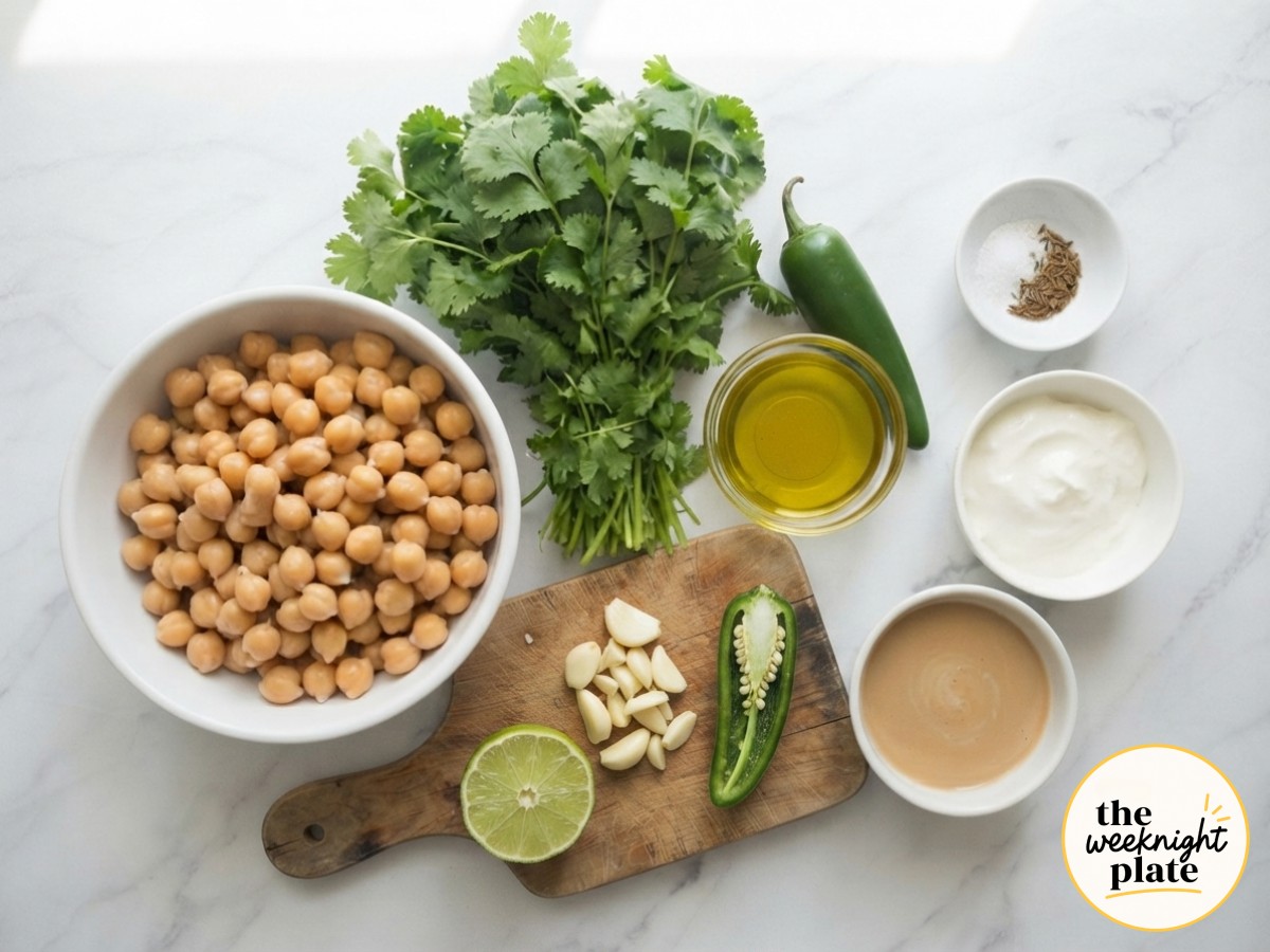 Garlic, jalapeño, and lime prepped on a board for a mediterranean hummus bowl recipe
